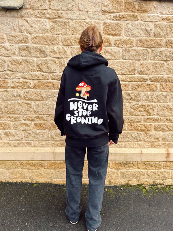 Black oversized hoodie with mushroom graphic and Never stop growing slogan