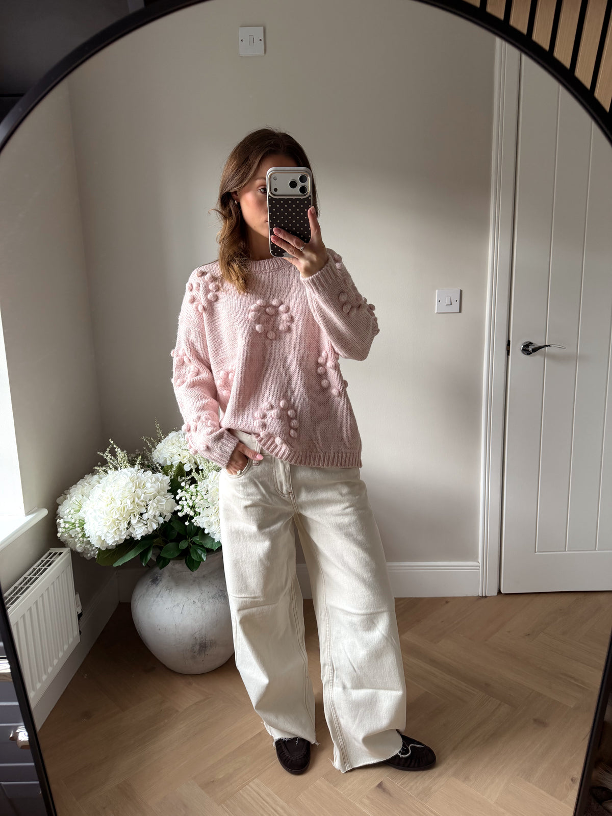 Pink pom pom jumper paired with baggy cream jeans and brown loafers.