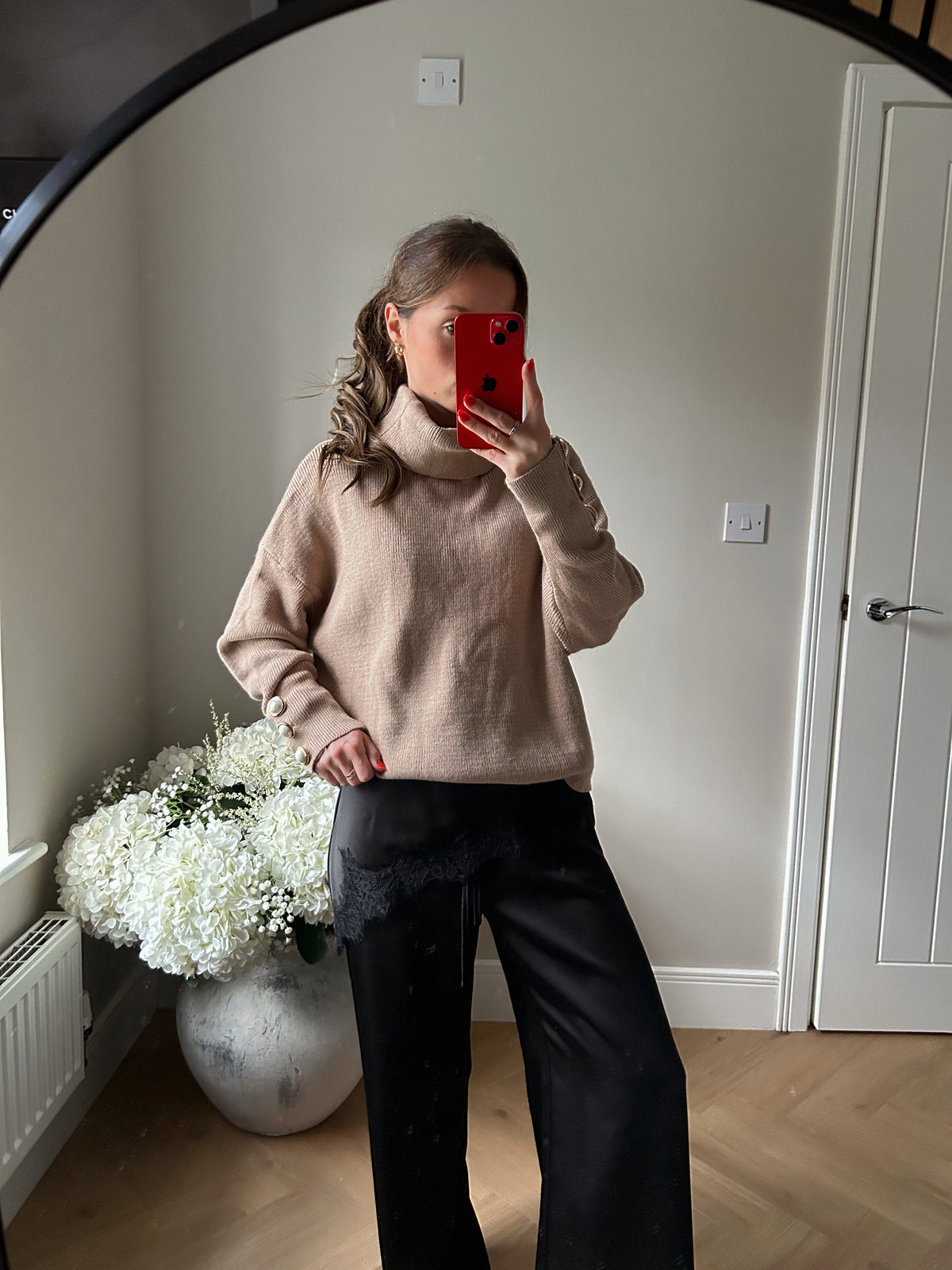 Beige roll neck fine knit jumper with pearl button cuffs.