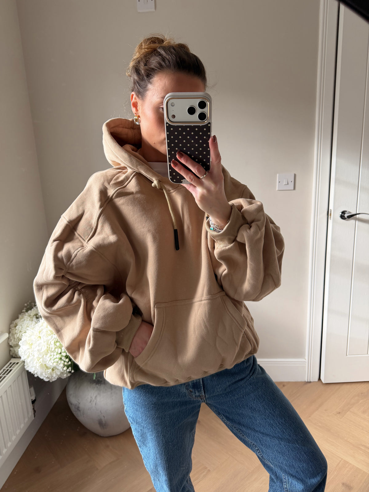 Women’s beige oversized hoodie with ruched sleeves styled for casual loungewear outfit