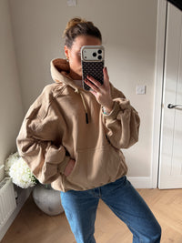 Women’s beige oversized hoodie with ruched sleeves styled for casual loungewear outfit
