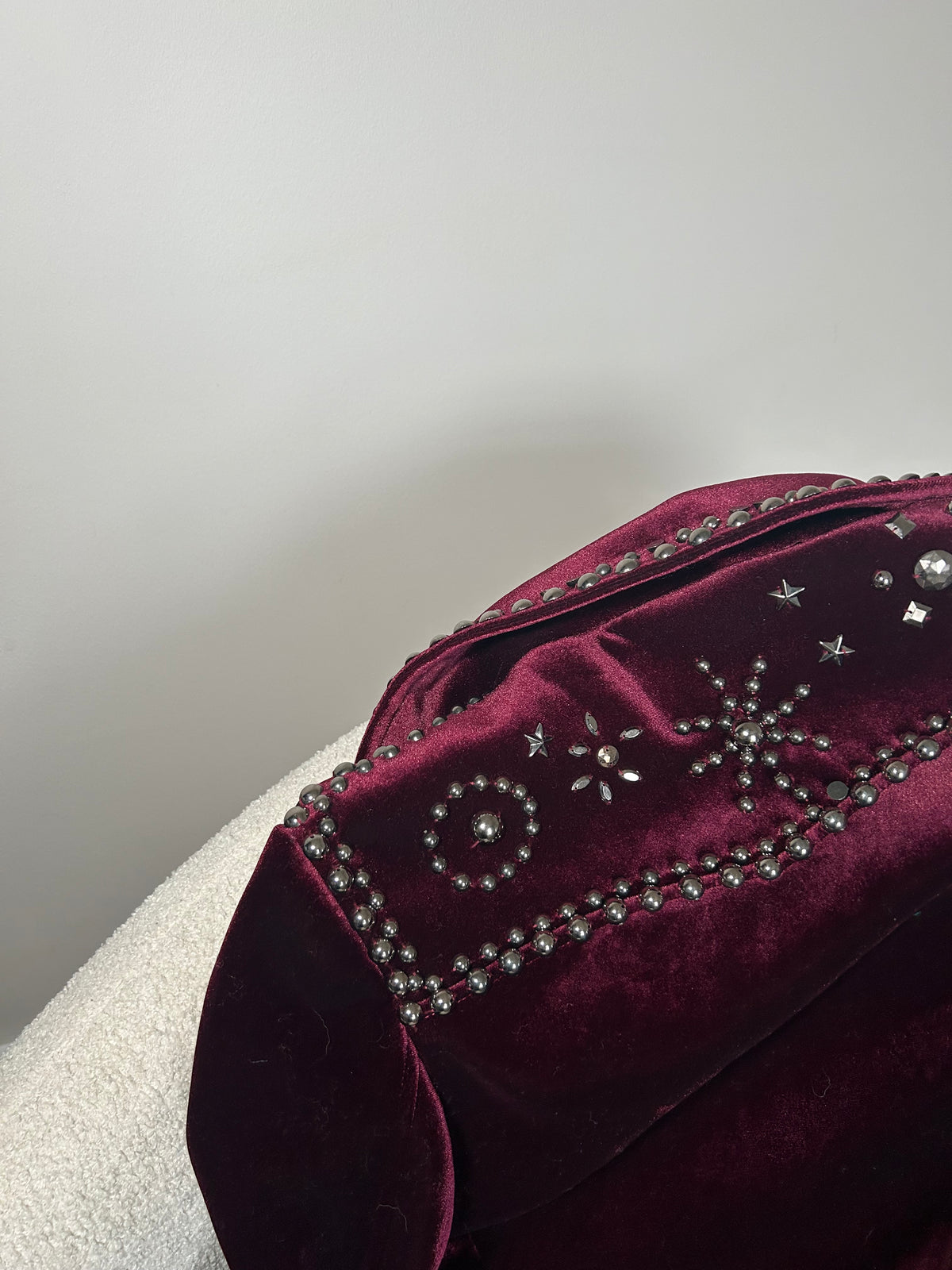 Close-up of a wine red velvet jacket with bead embellishments on the back.