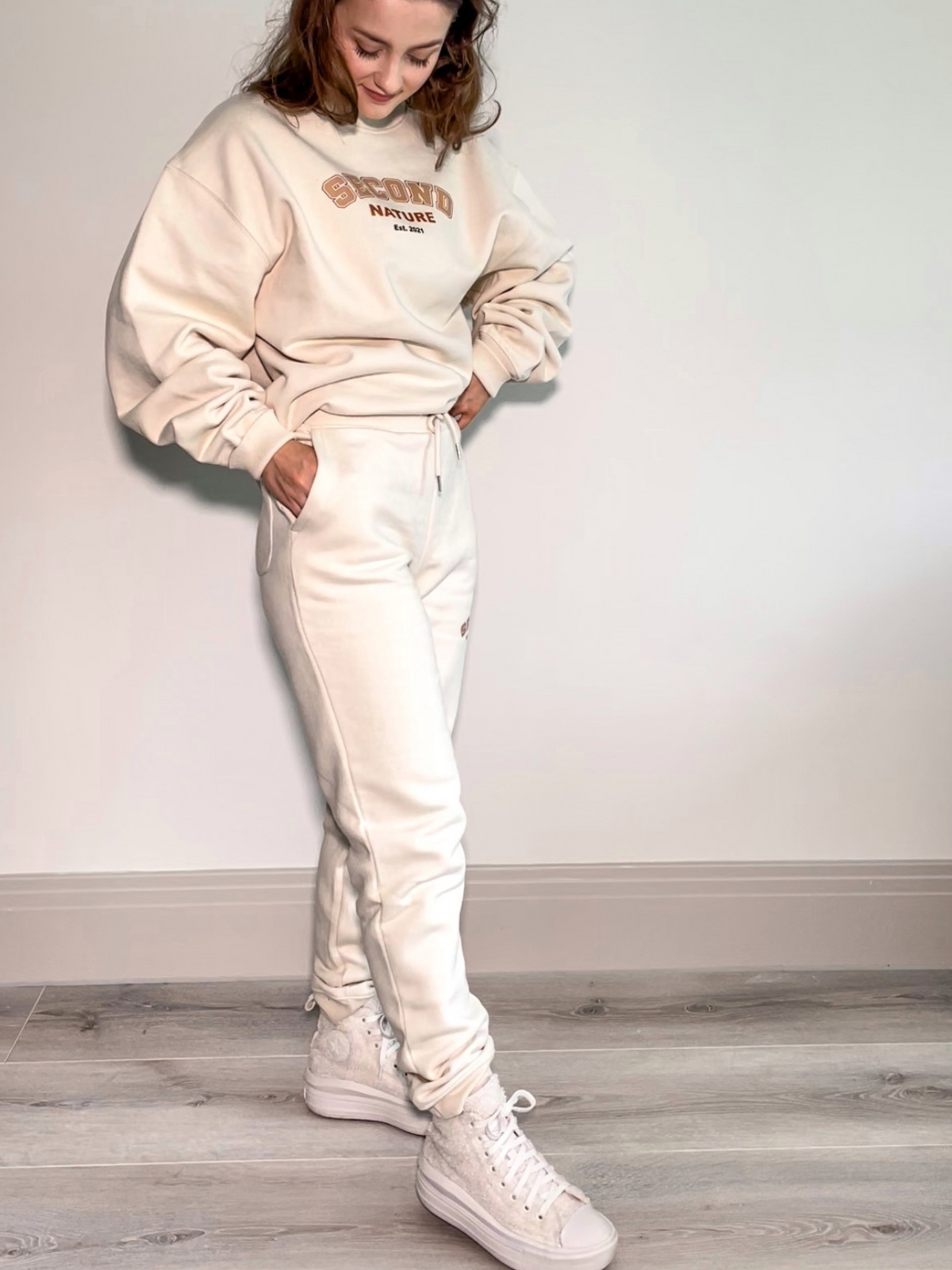 Cream joggers with Second Nature college style logo near pocket